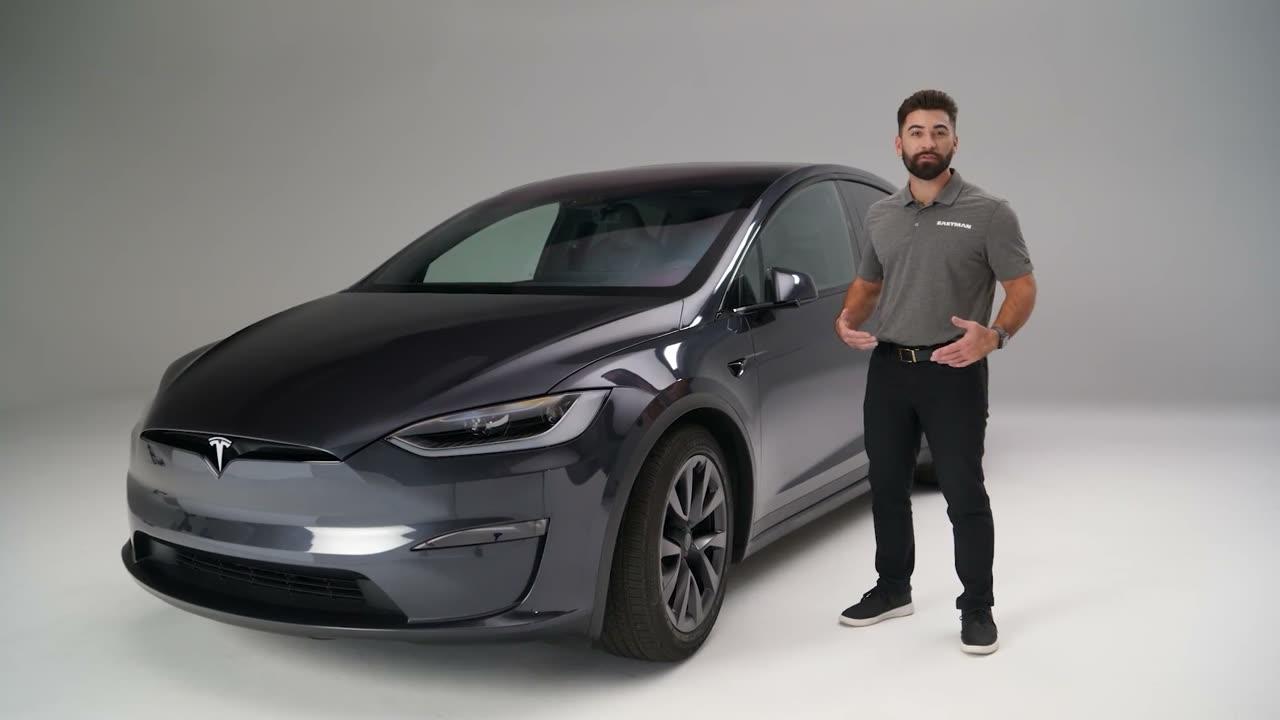 Installer beside a dark SUV in a studio — video poster