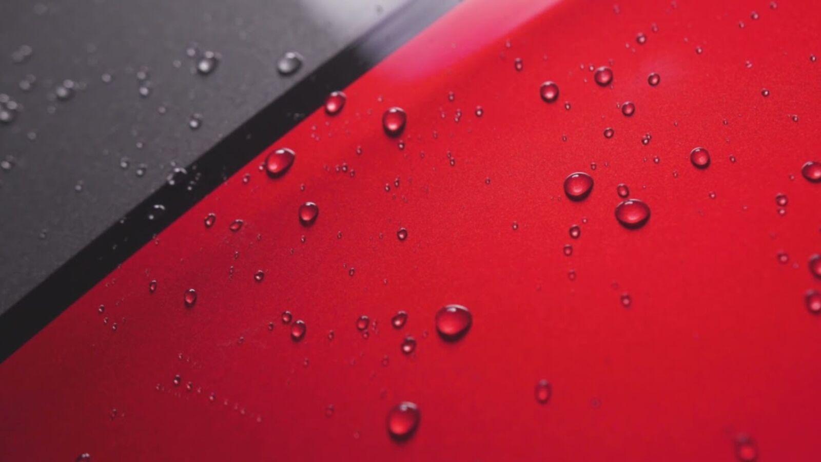 Water beading on red paint, the opening frame of the hero video